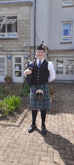 Young bagpiper entertains customers at Bield's Linlithgow development